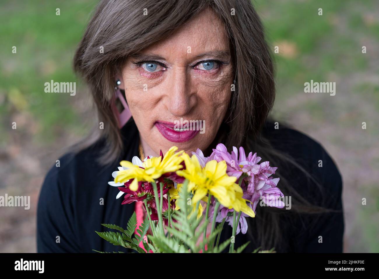 Top view portrait of a mature transgender woman with a bouquet of flowers Stock Photo