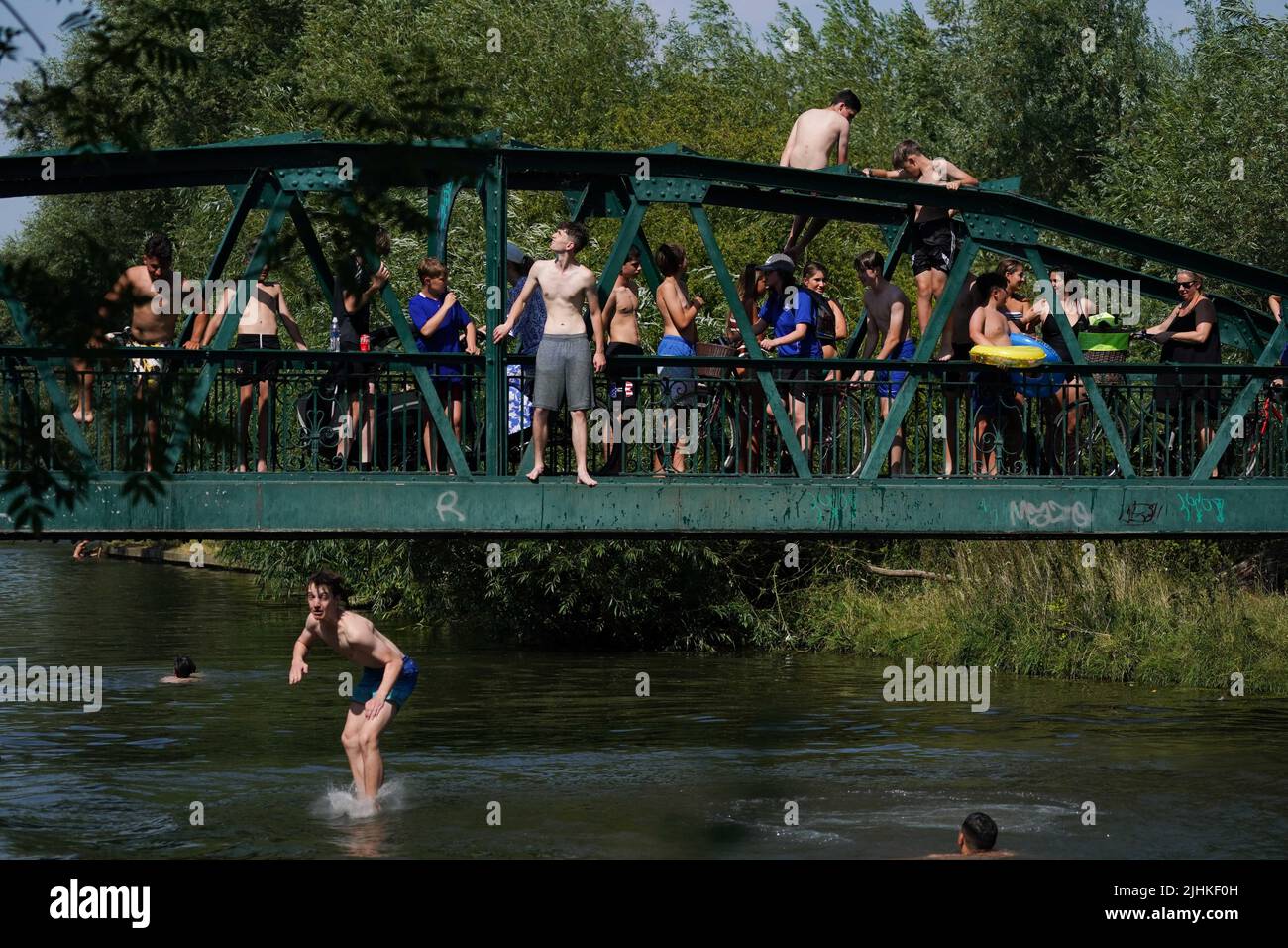 People jump into the Cam in Cambridge. Temperatures have reached 40C for the first time on record in the UK, with 40.2C provisionally recorded at London Heathrow, the Met Office has said. Picture date: Tuesday July 19, 2022. Stock Photo