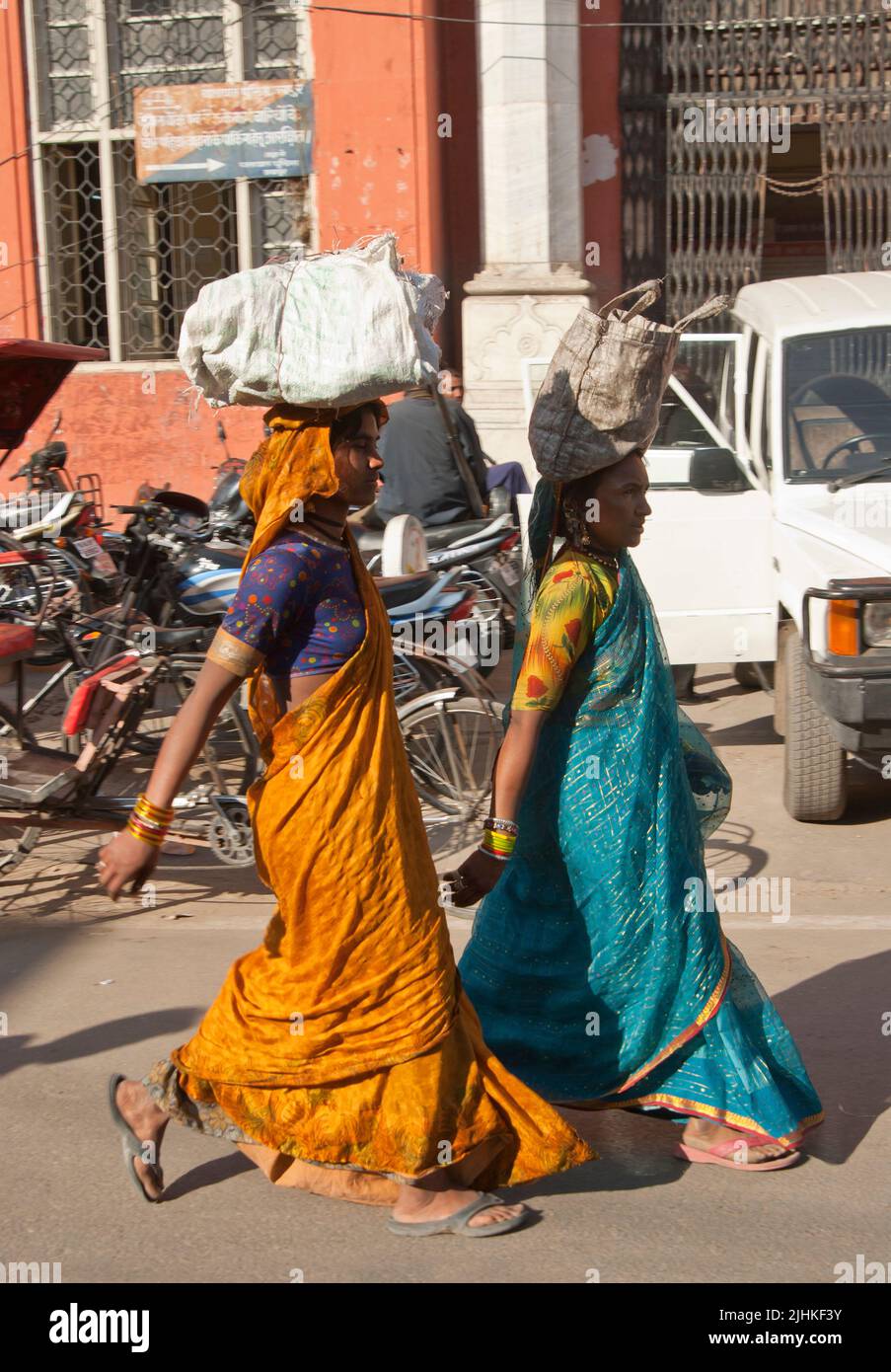Women carry on head while walking, India Stock Photo