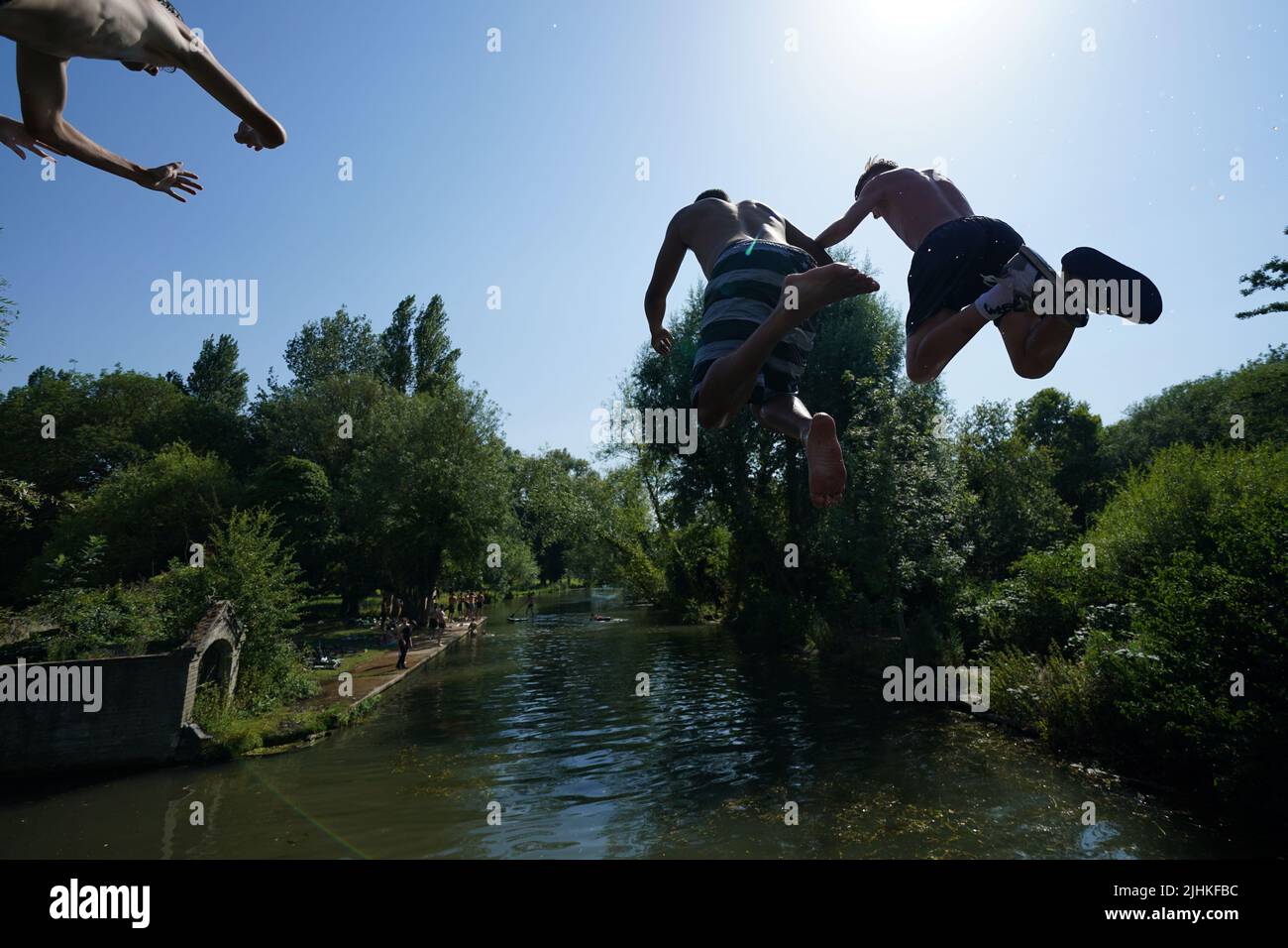 People jump into the Cam in Cambridge. Temperatures have reached 40C for the first time on record in the UK, with 40.2C provisionally recorded at London Heathrow, the Met Office has said. Picture date: Tuesday July 19, 2022. Stock Photo