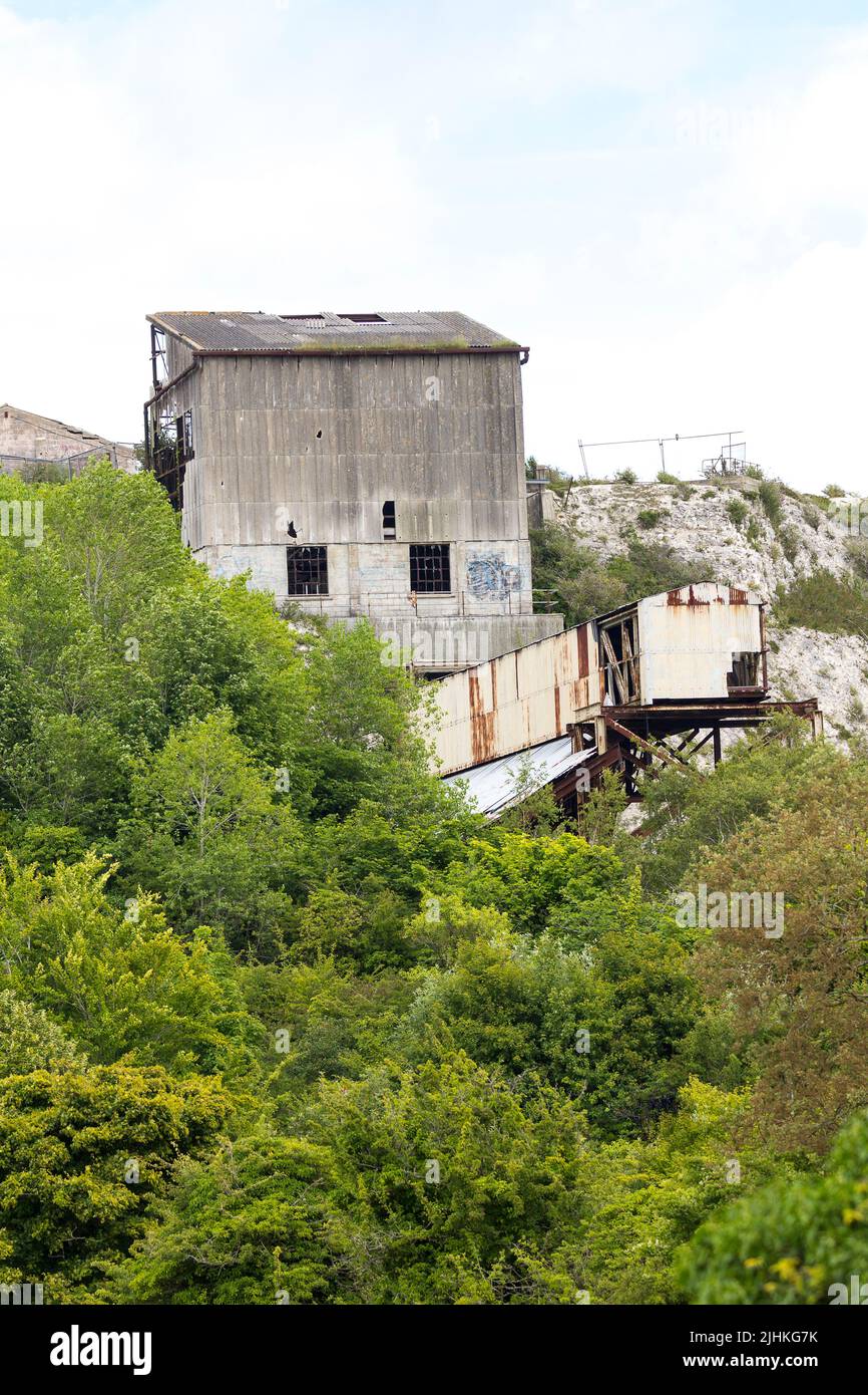 Asbestos clad shoreham cement works now derelict with support towers and conveyors broken windows and asbestos sheets a brown field site fenced off Stock Photo