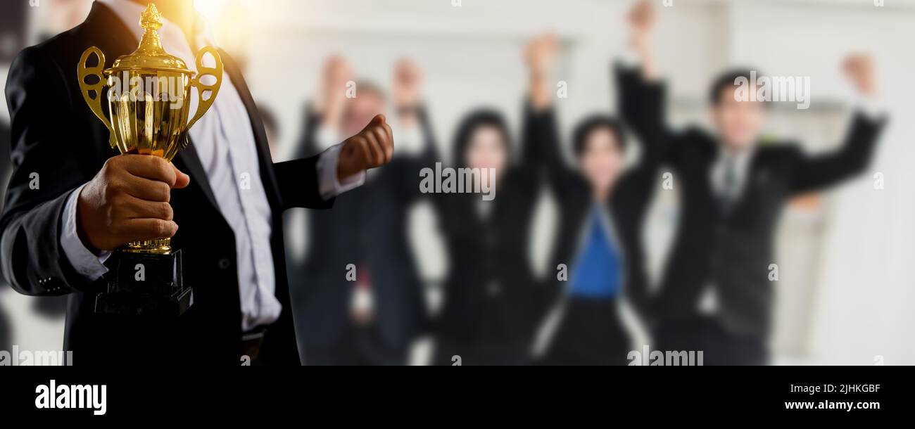 Manager, businessman or boss holding champion golden trophy for winner