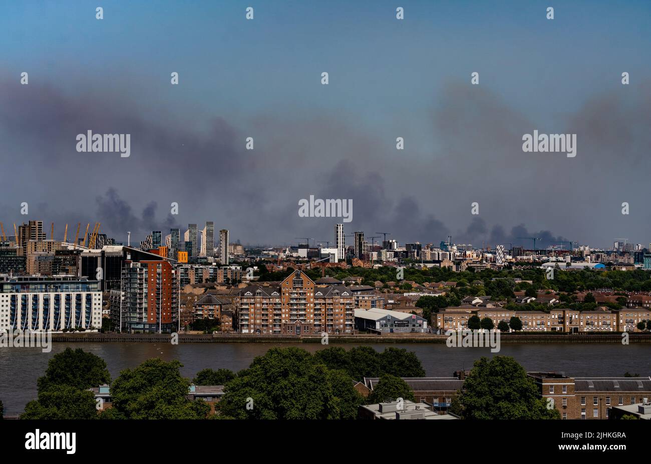London, UK. 19th July, 2022. UK Weather: Heatwave fires. Smoke is seen rising in the distance over the Thames from multiple fires in Upminster and Wennington in east London. Currently 175 firefighters and 30 fire engines are battling the blaze with around three hectares of cornfield and some scrubland remains alight as heatwave temperatures exceeded 40C on Tuesday afternoon. Credit: Guy Corbishley/Alamy Live News Stock Photo