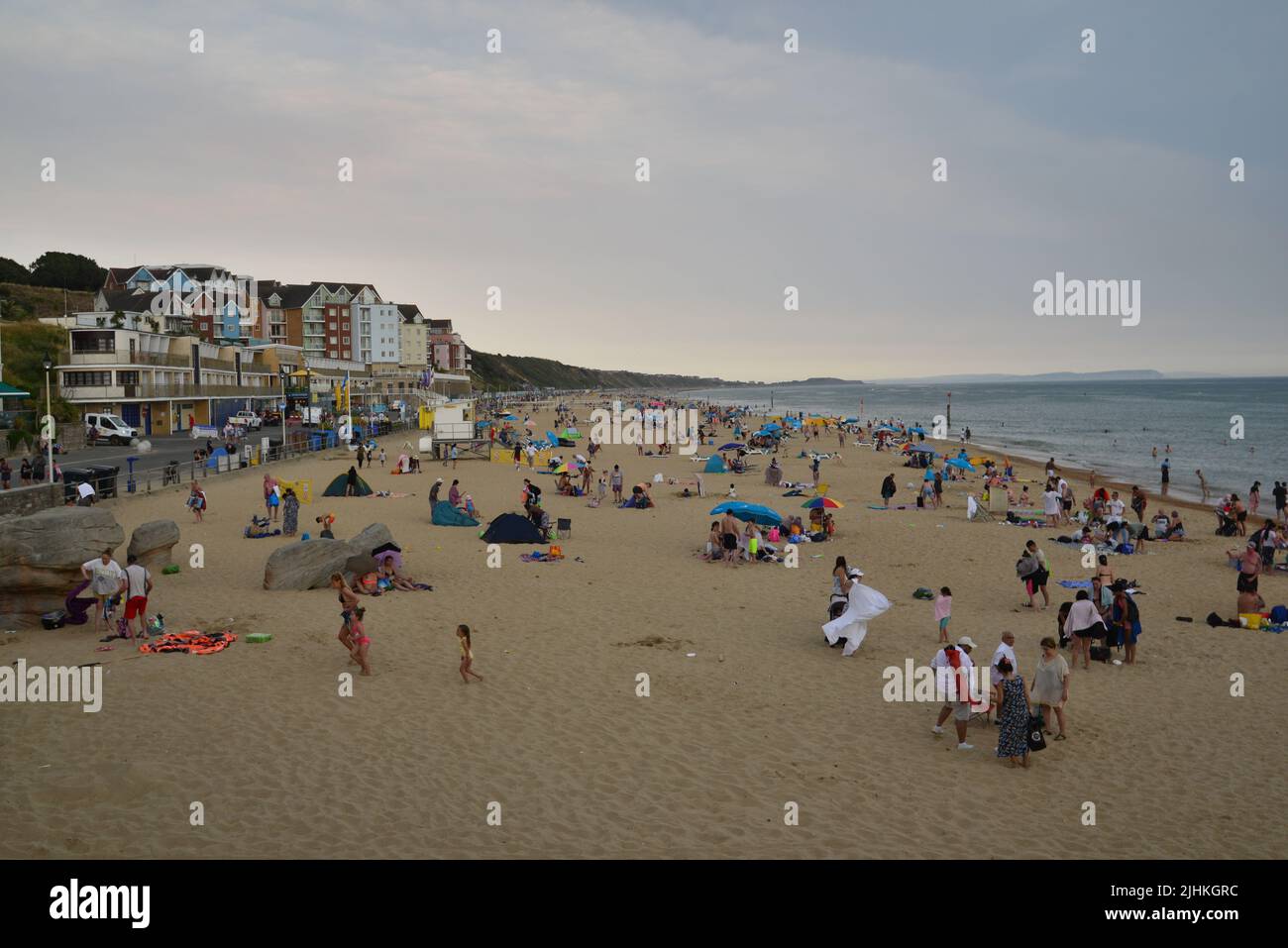 Boscombe, Bournemouth, Dorset, England, UK, 19th July 2022, Weather. The end is nigh for record breaking heatwave. Dark clouds and a rain shower over a busy beach in the afternoon has people running for cover. Credit: Paul Biggins/Alamy Live News Stock Photo