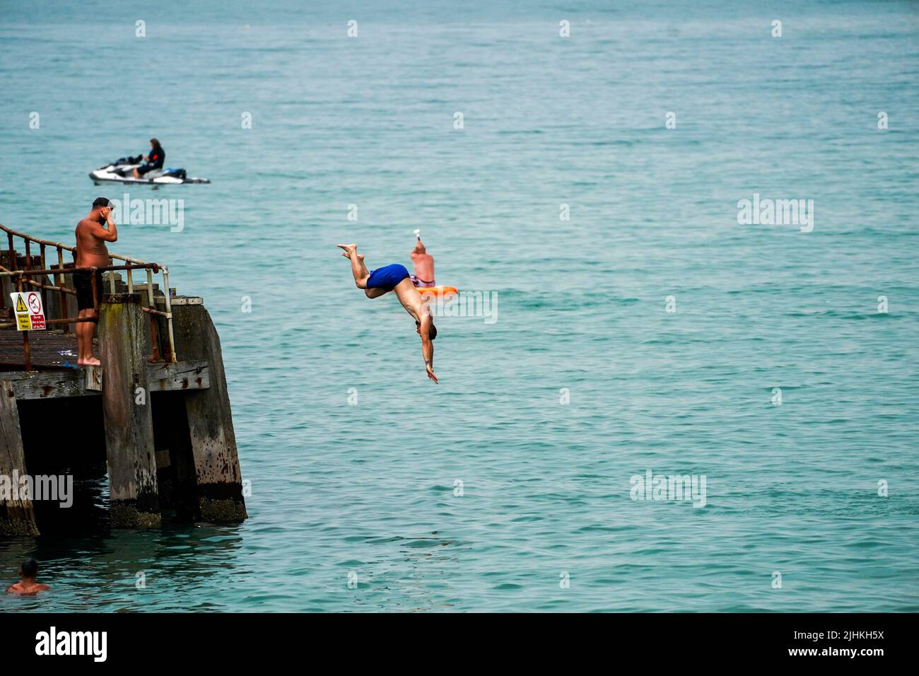 A man jumps from the pier in Bournemouth. Temperatures have reached 40C for the first time on record in the UK, with 40.2C provisionally recorded at London Heathrow, the Met Office has said. Picture date: Tuesday July 19, 2022. Stock Photo