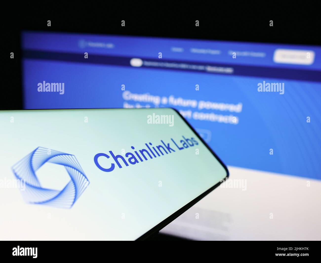Mobile phone with logo of American blockchain company Chainlink Labs on screen in front of business website. Focus on center of phone display. Stock Photo