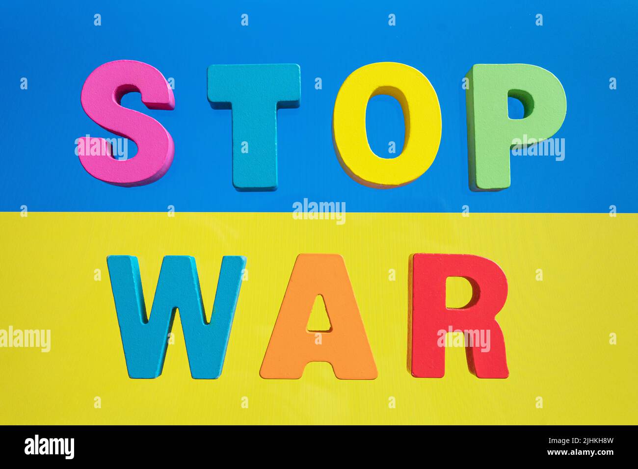 The word stop war on the background of the yellow blue flag of Ukraine. The concept of war and peace. Stock Photo