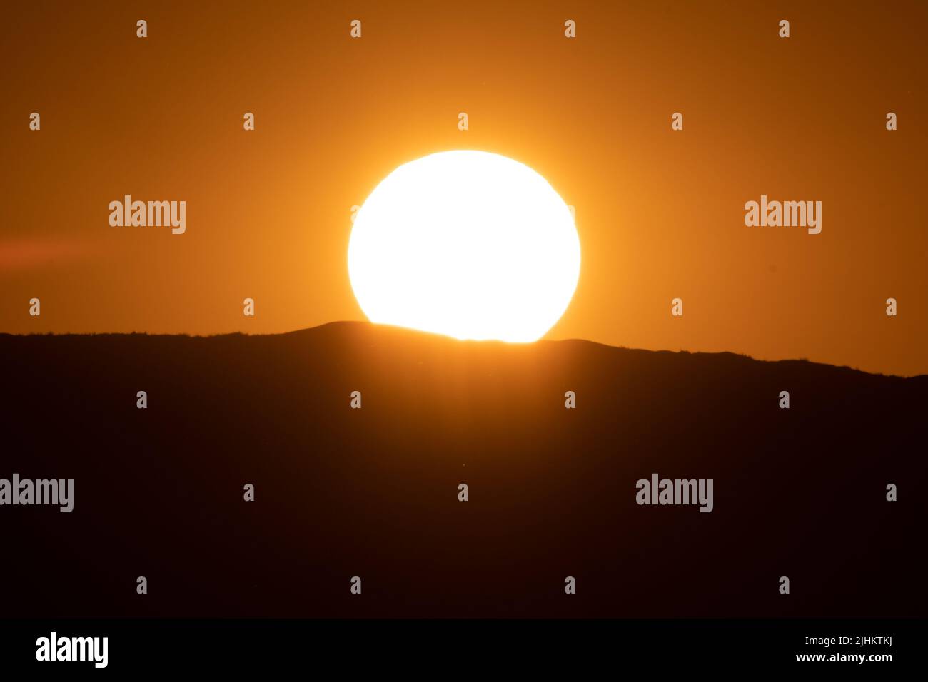 The fireball of the setting sun in Namibia Africa Stock Photo