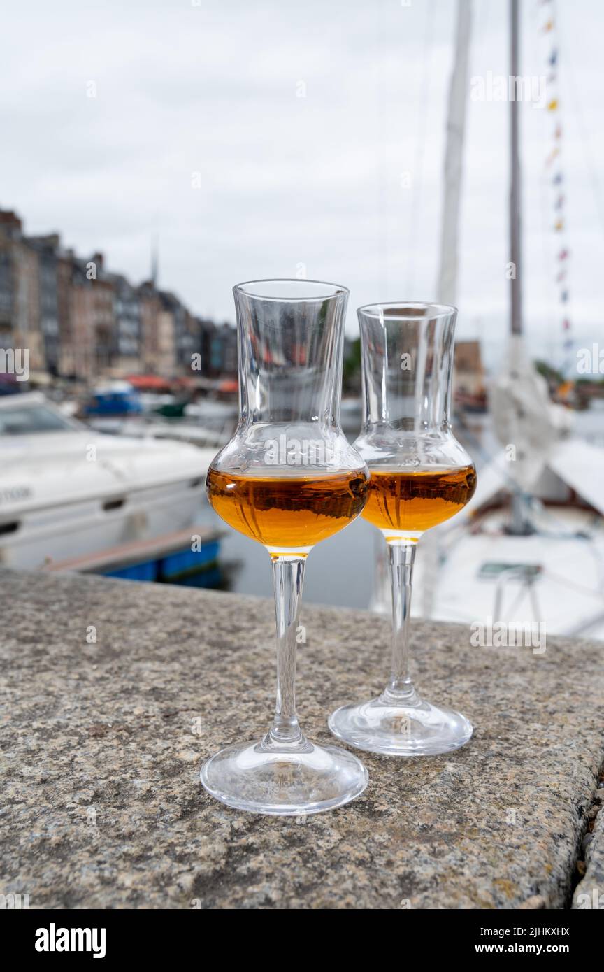 Tasting of apple calvados drink from glasses in old Honfleur harbour with boats and old houses