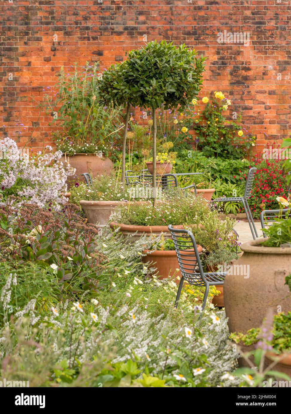 Large planters with tables and chairs in between, in the Bee and Butterfly Garden, RHS Bridgewater, Salford. UK. Stock Photo