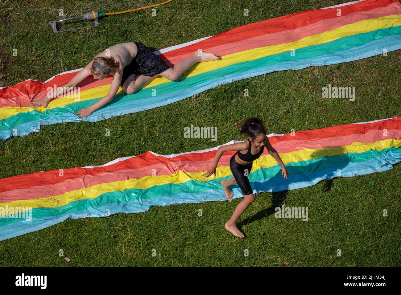 London, UK. 19th July, 2022. UK Weather: City Heatwave. Locals in east London cool off with water slides as heatwave temperatures finally exceed 40C on Tuesday afternoon. Credit: Guy Corbishley/Alamy Live News Stock Photo