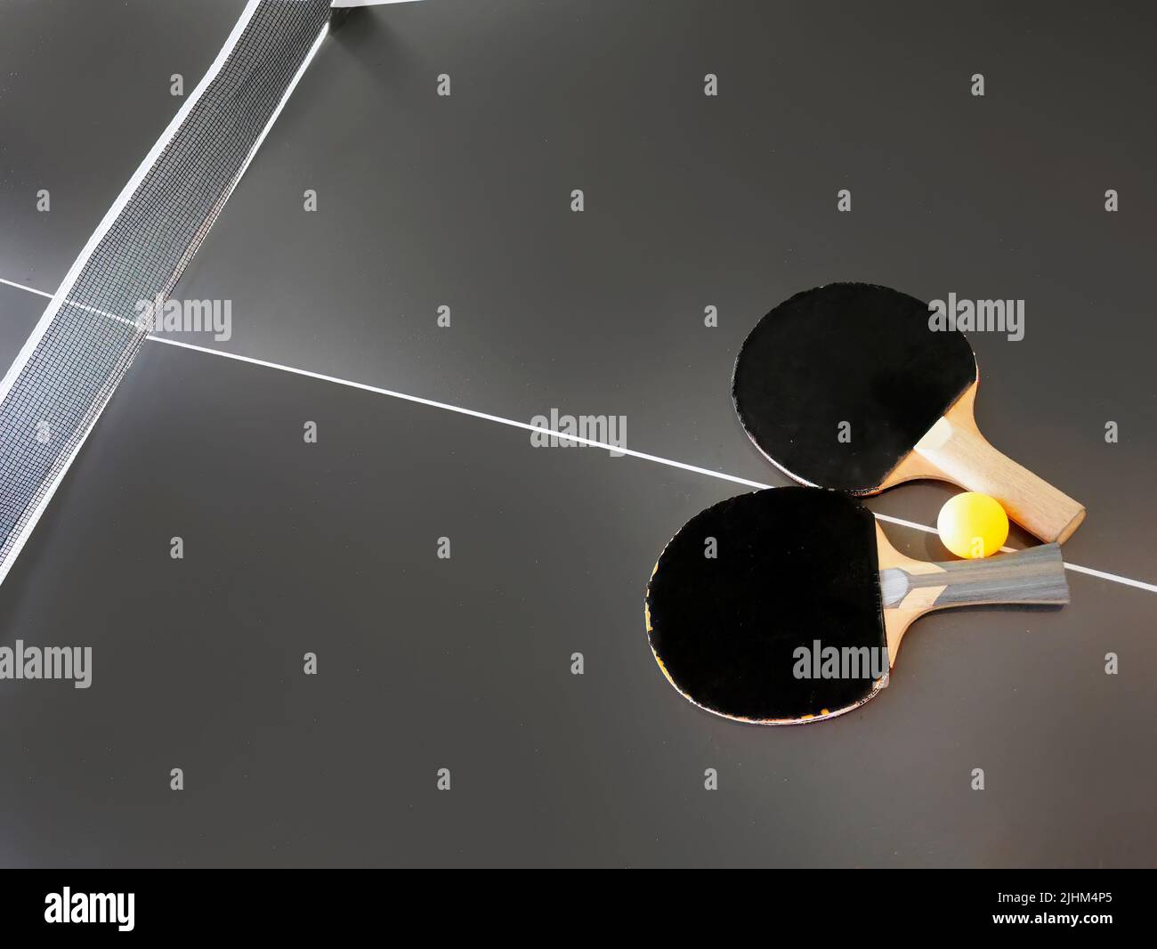 High angle view of dilapidated table tennis bat and ball on dark color table Stock Photo Alamy