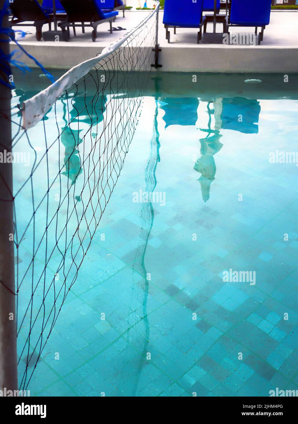 Detail of volleyball net over blue water swimming poo, Selective focus Stock Photo