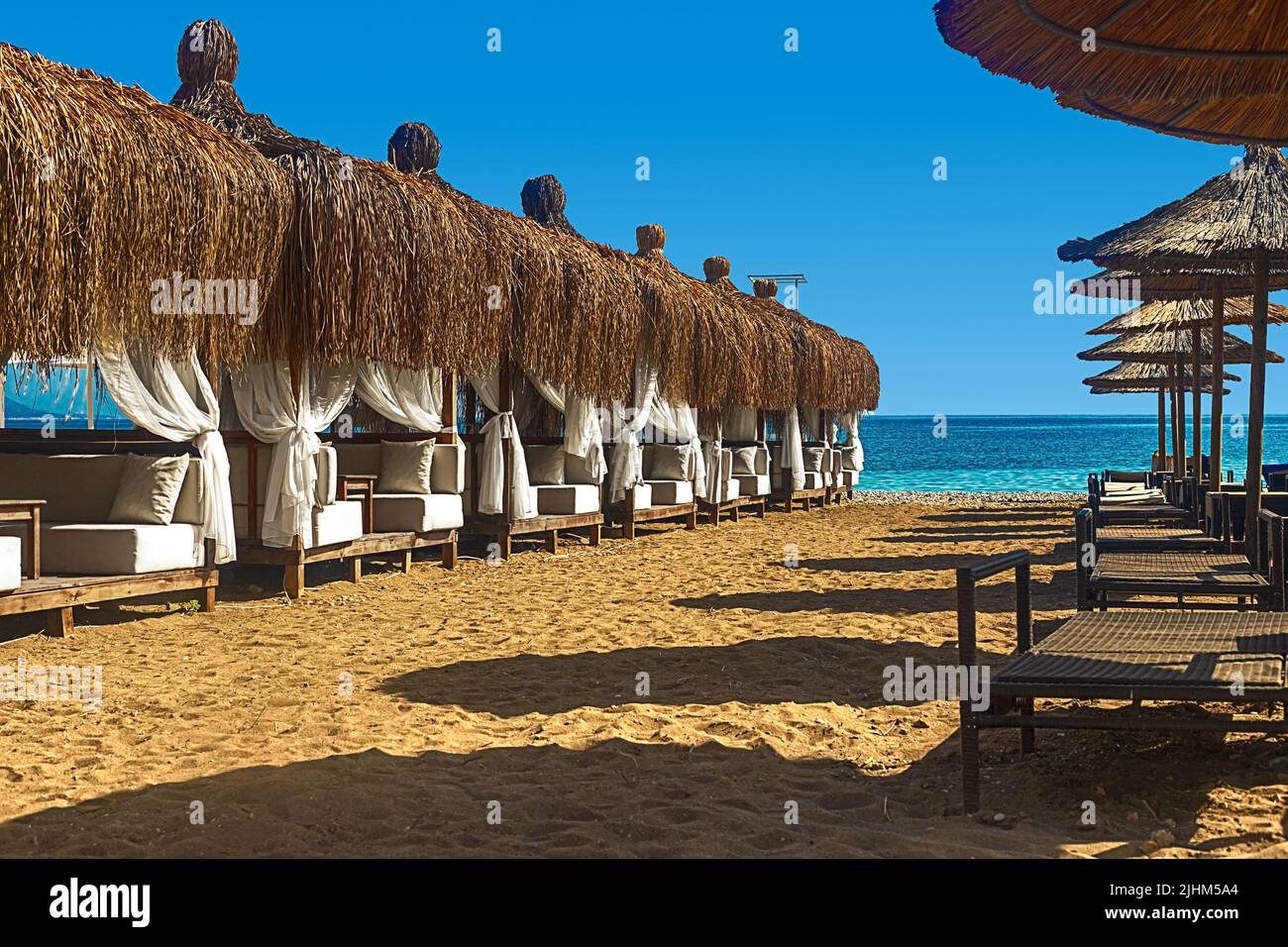 View of deck chairs and umbrellas on the sandy beach of Kemer, Turkey. Stock Photo