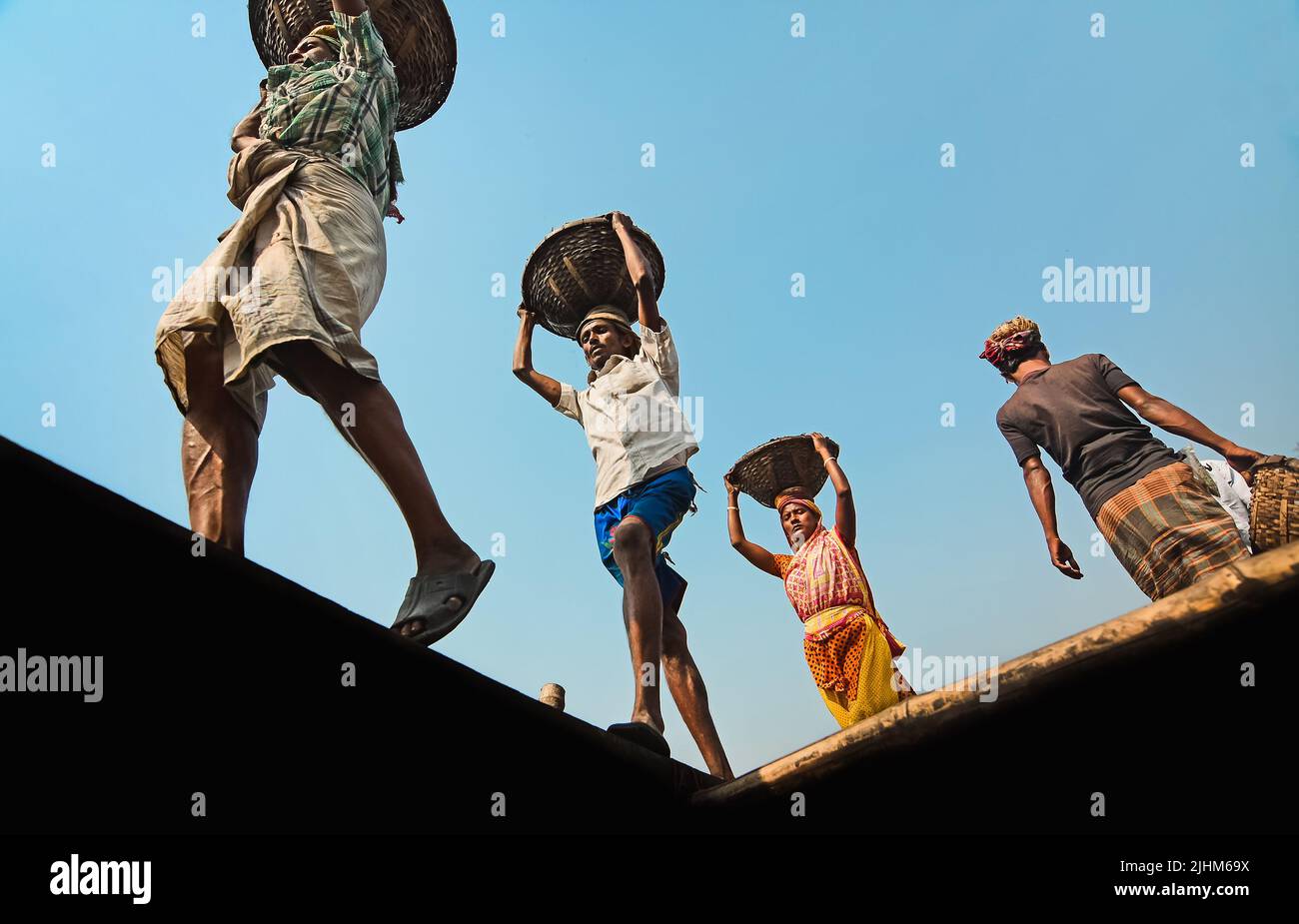 Women workers carrying baskets filled with coal on their head in the