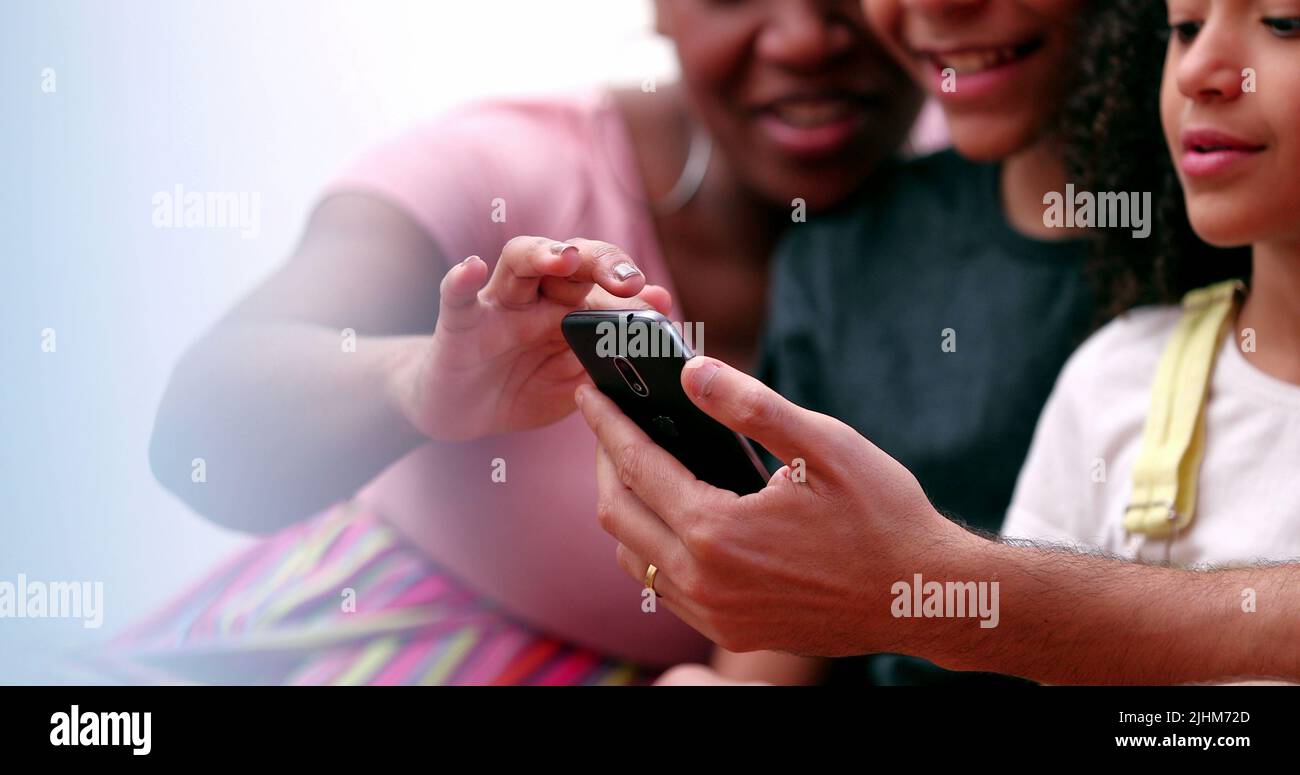 Happy multiracial family using smartphone Stock Photo