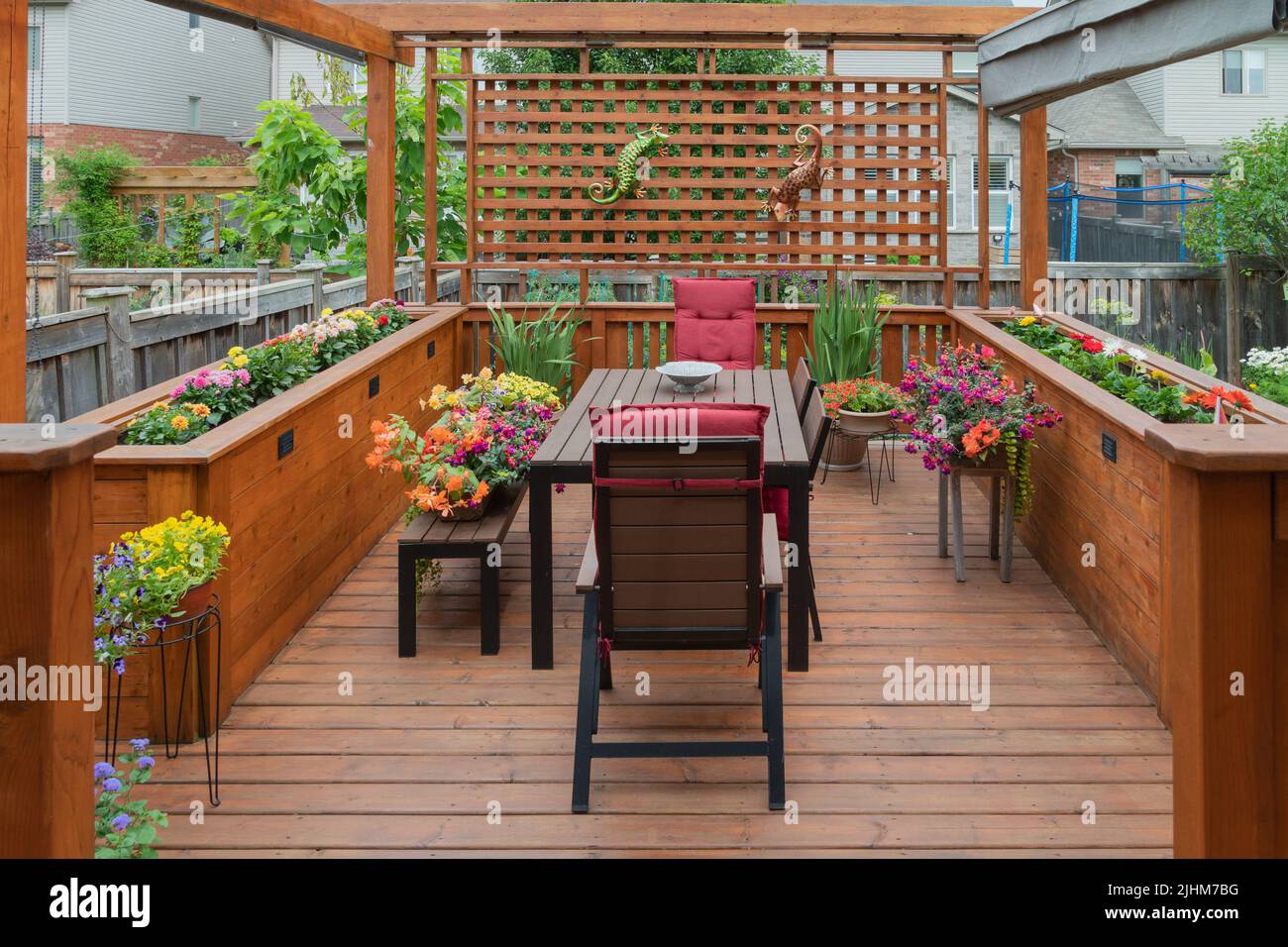 Beautiful deck with table and chairs and two wooden flower beds Stock