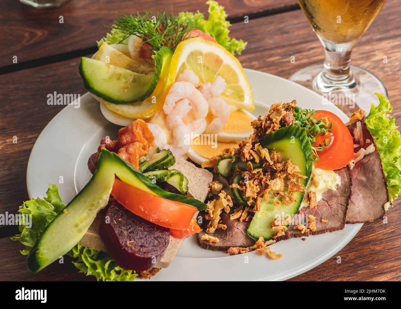 Danish traditional Smørrebrød or open sandwiches served in a plate, roast beef with remoulade, tomato and shredded horseradish on Danish rye bread Stock Photo