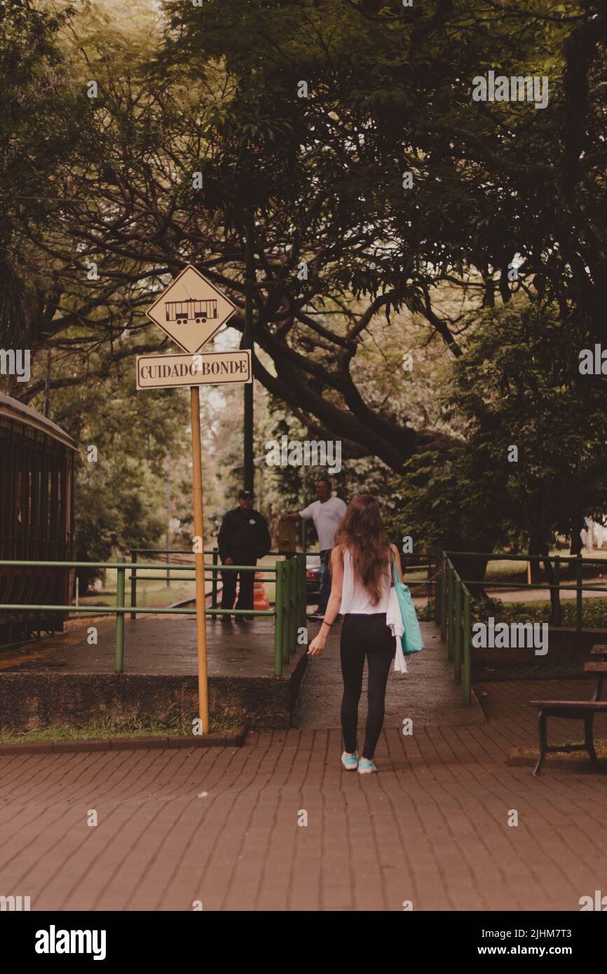 young woman backwards walking to catch the tram Stock Photo