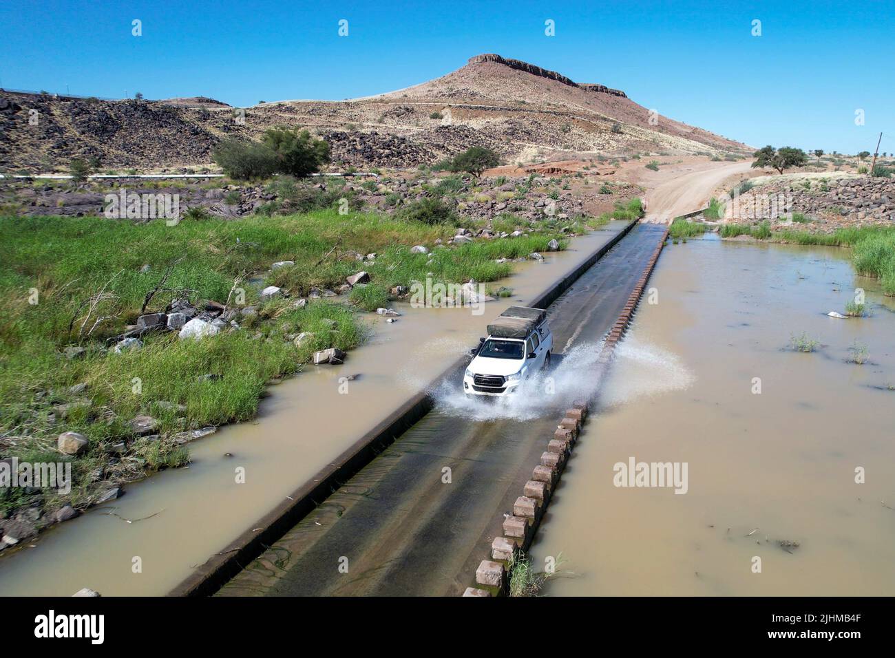 Drone footage of an off-road vehicle driving through the Lion River in Namibia Stock Photo