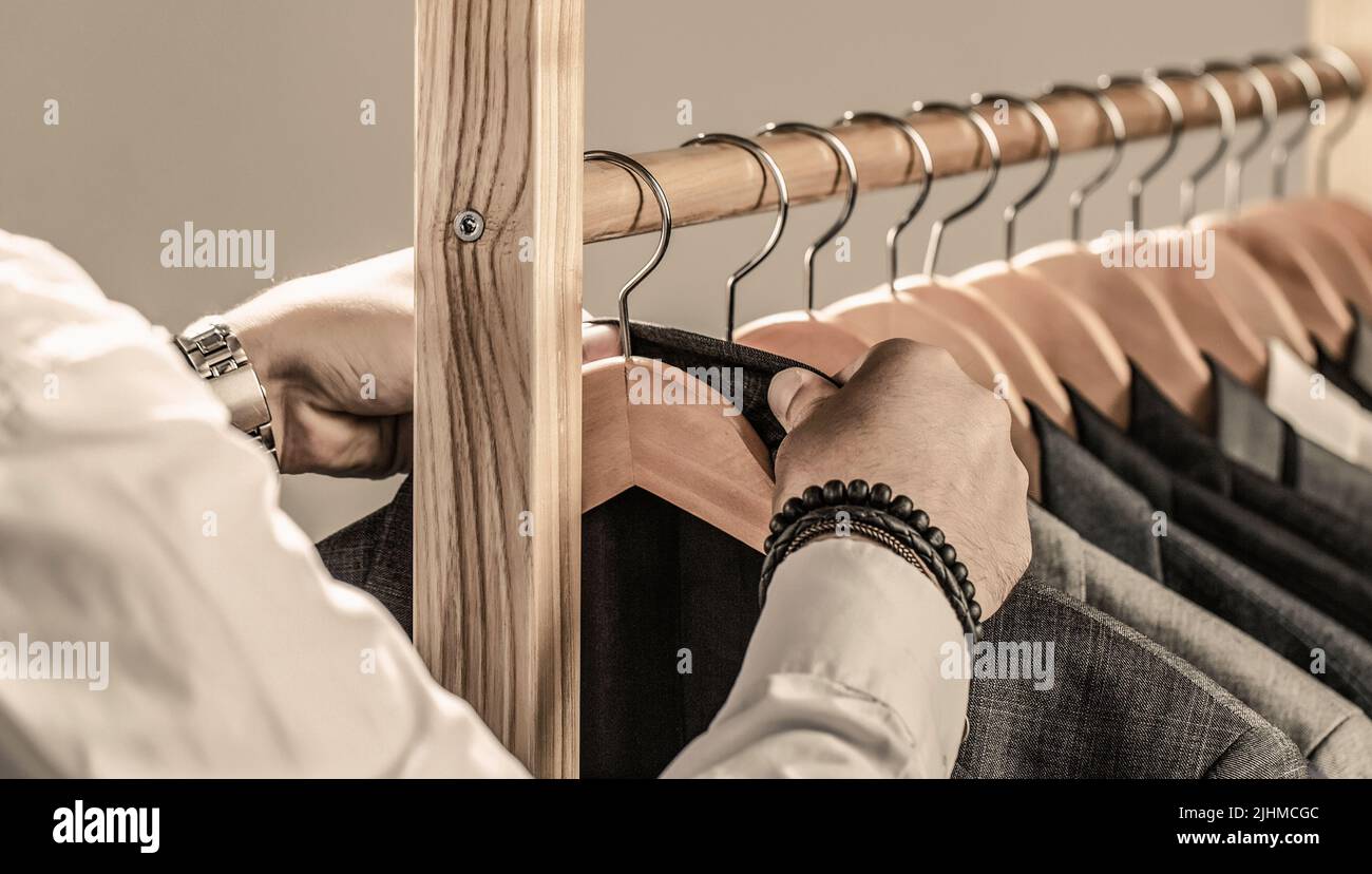 Fashion man in classical costume suit. Tailor, tailoring. Stylish men's suit. Male suits hanging in a row. Men clothing, boutiques Stock Photo