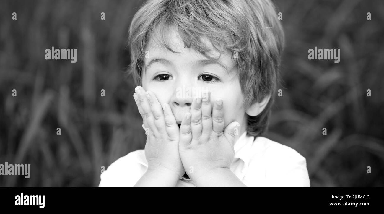 Smiling amazed or surprised child boy. Child expressing surprise with his hands in his face. Shocked and surprised boy. Funny child boy Stock Photo