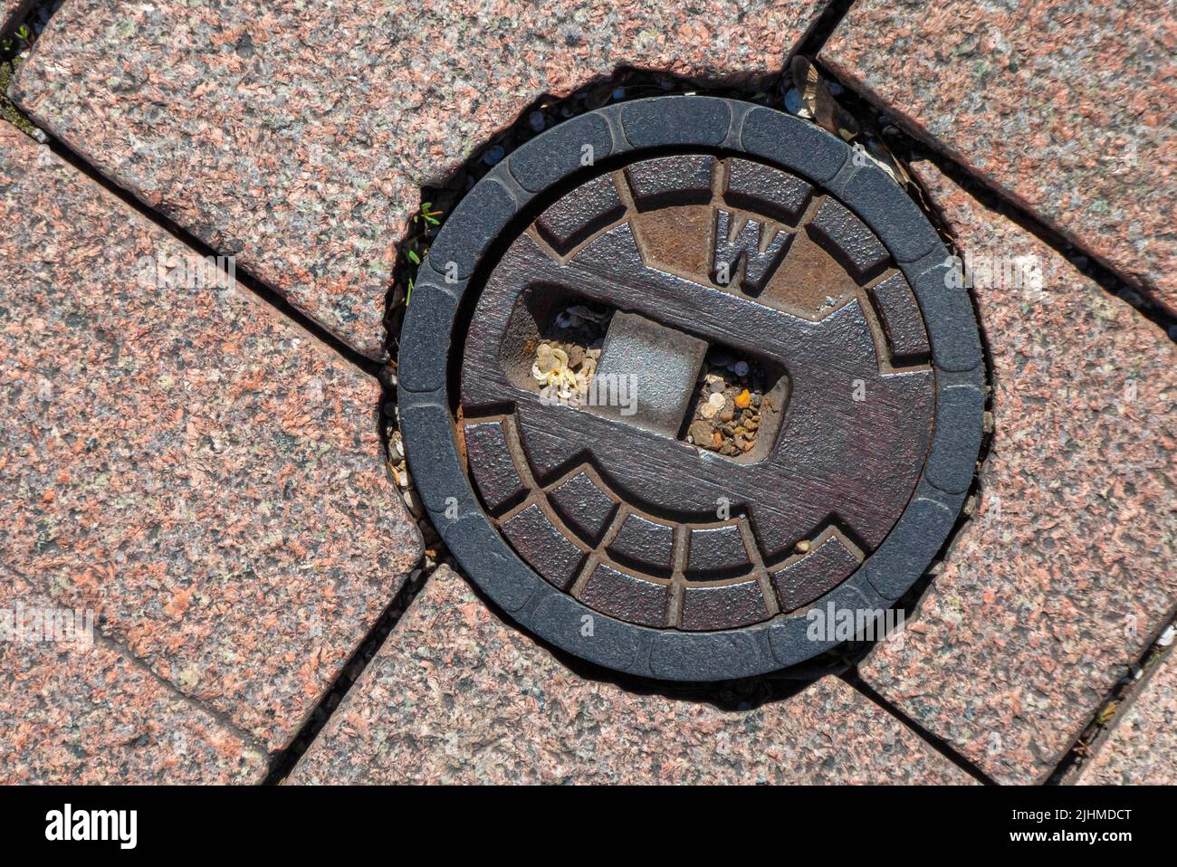Street cap for municipal water supply with paving stones on a sidewalk in germany Stock Photo