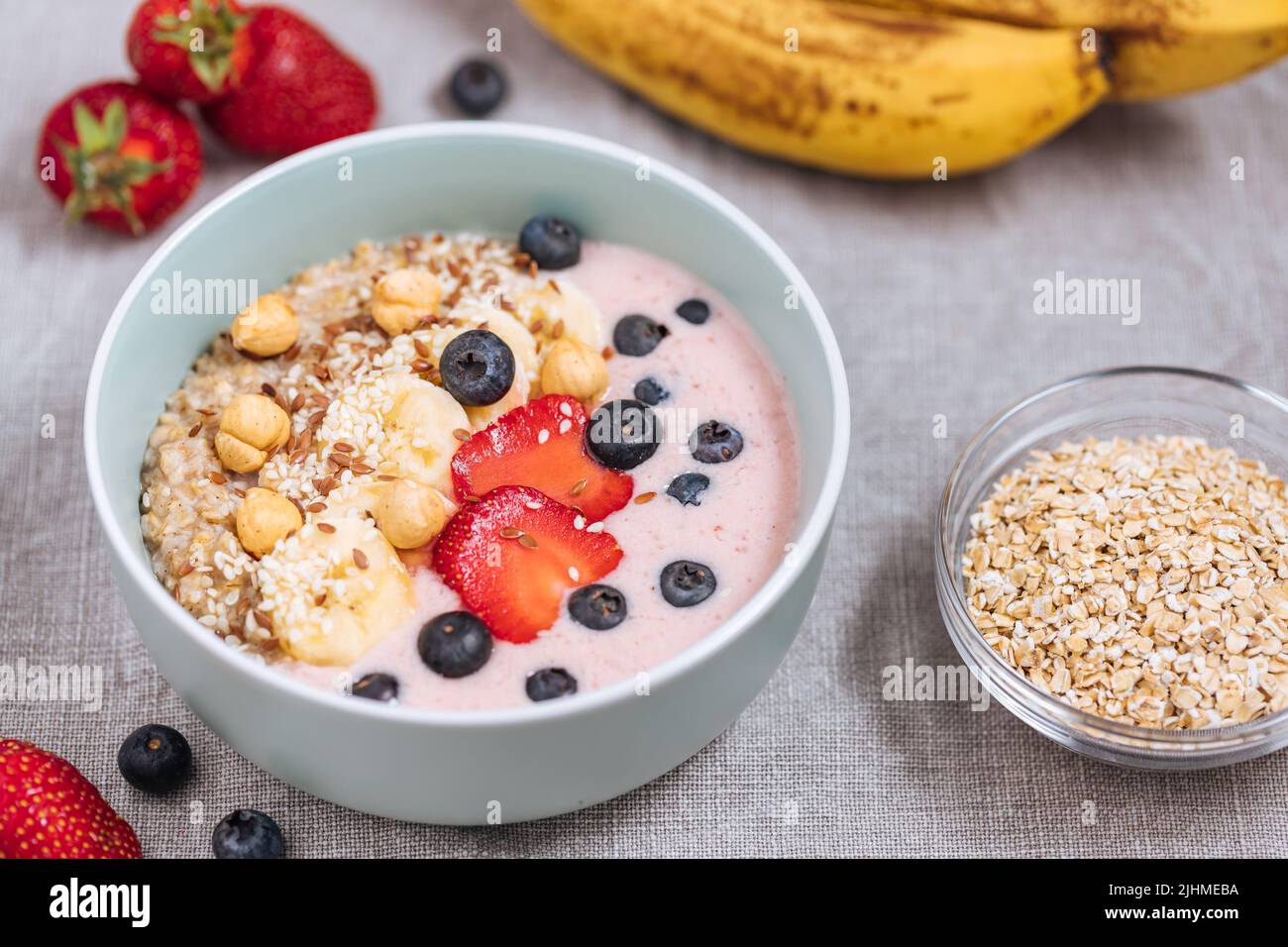 Healthy oatmeal with yoghurt, blueberries, strawberries, banana and seeds. Healthy fitness meal, superfood. Stock Photo