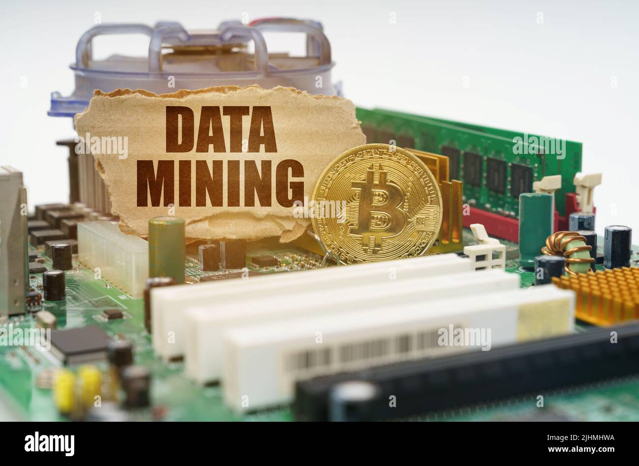 Crypto - business concept. On the motherboard lies a bitcoin coin and a cardboard sign with the inscription - Data mining Stock Photo
