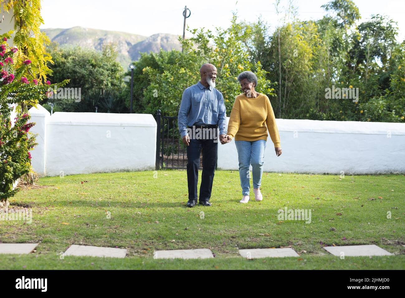Image of happy african american senior couple walking in garden Stock ...