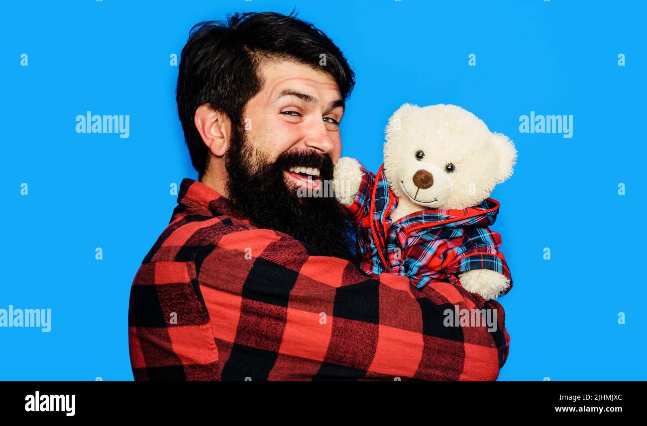 Happy man in plaid shirt with teddy bear. Bearded guy with plush toy. Birthday. Gift and present. Stock Photo