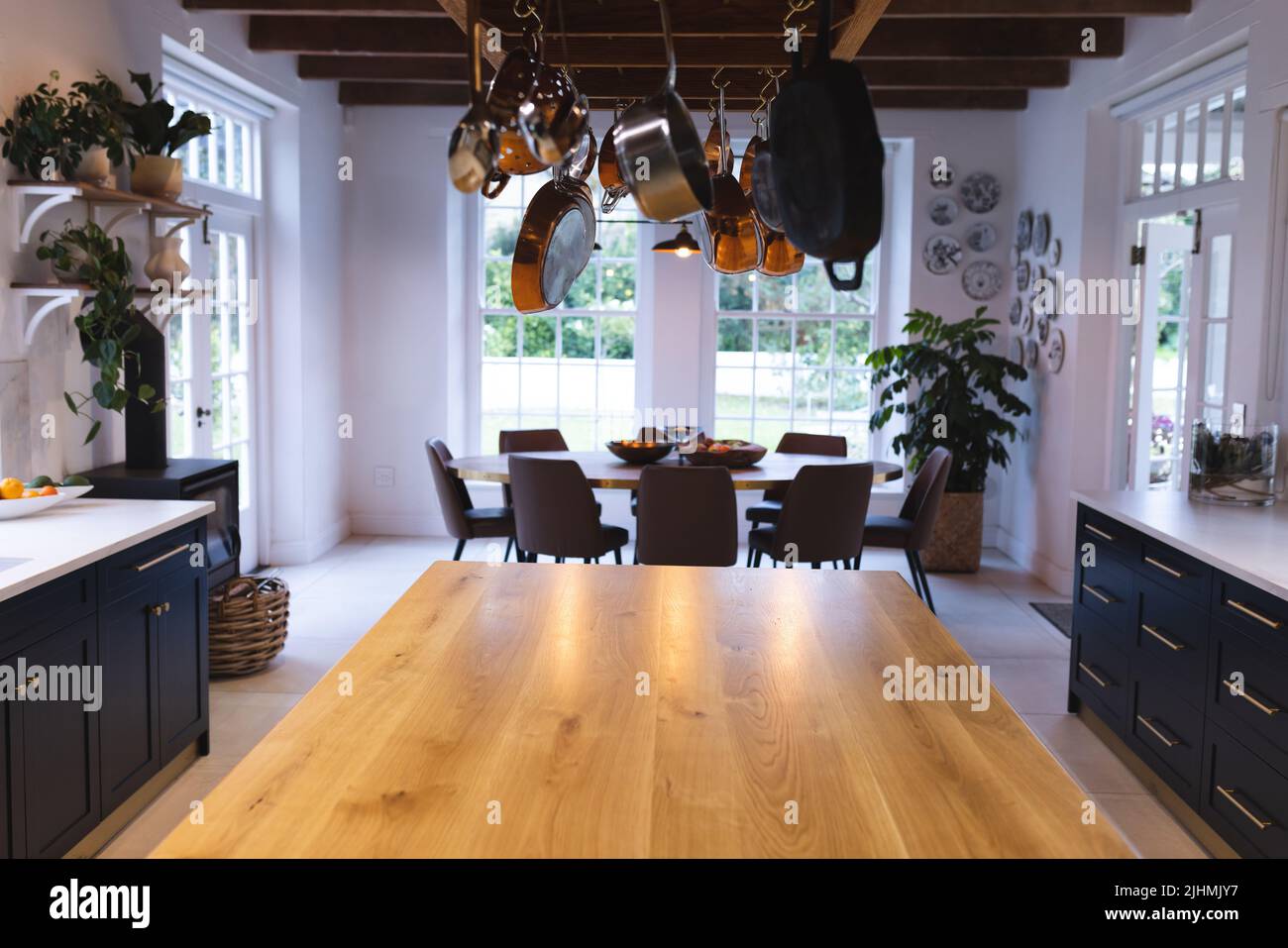Image of empty kitchen with pots hanging over table Stock Photo