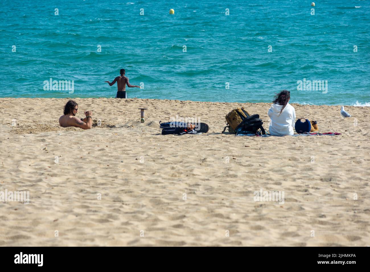Boscombe Beach, Bournemouth, Dorset, England, UK, 19th July 2022, Weather. Late afternoon hot sunshine on the south coast as the record breaking heatwave starts to moderate. A man digs a hole in the beach sand deep enough to stand in. Credit: Paul Biggins/Alamy Live News Stock Photo