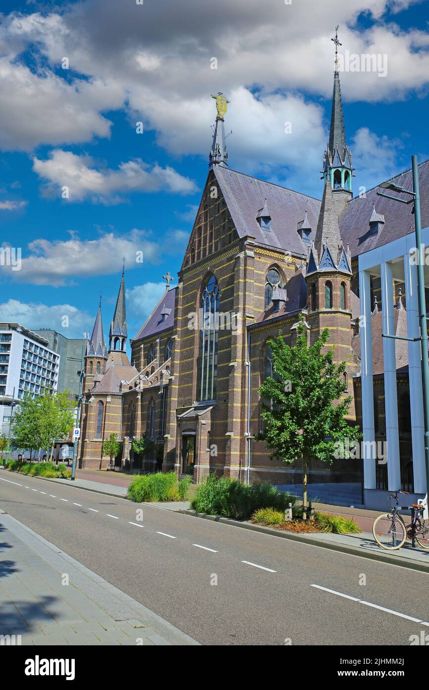 Eindhoven (Augustijnenkerk), Netherlands - July 17. 2022: City street with medieval augustine church, blue summer sky fluffy clouds Stock Photo