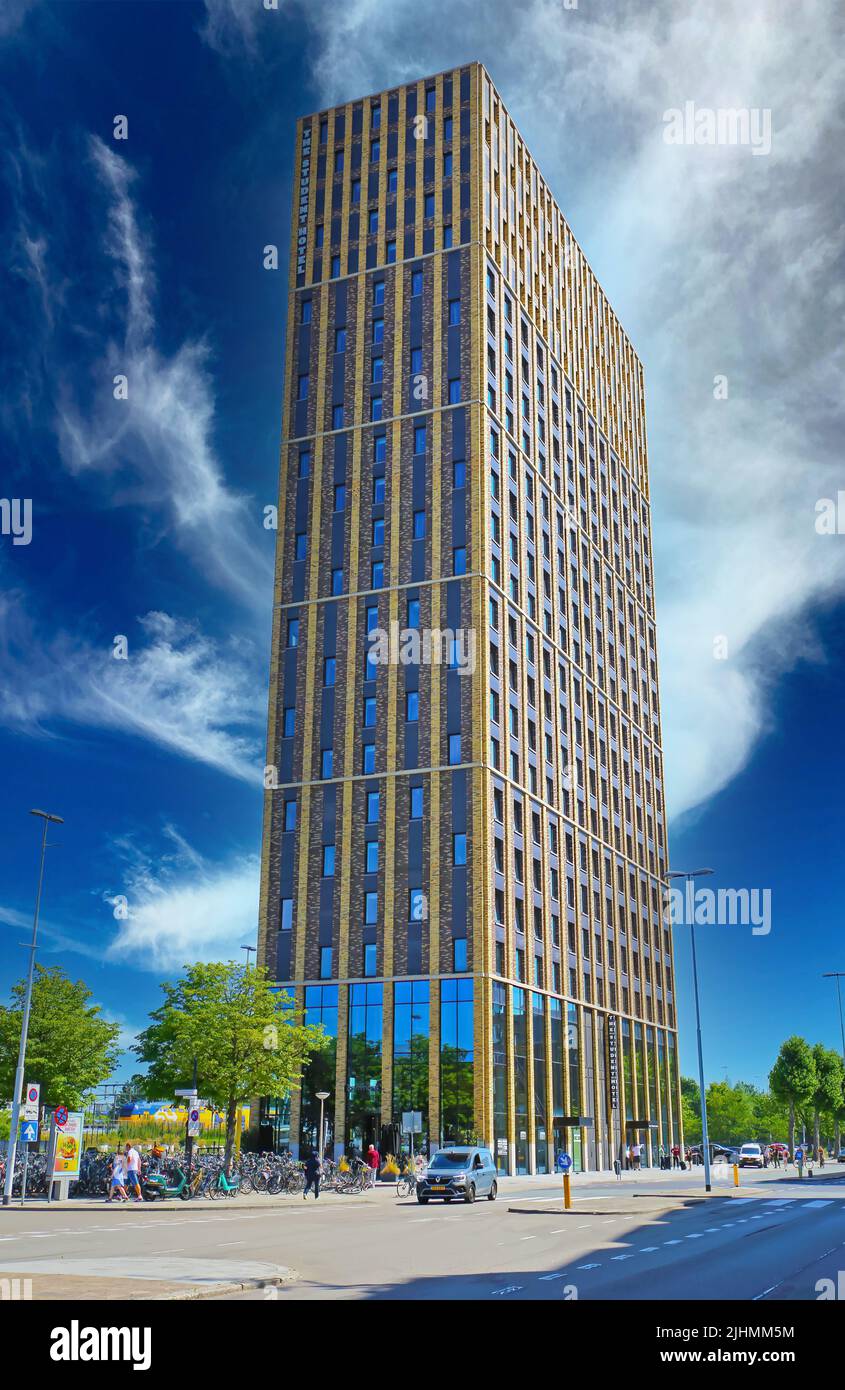 Eindhoven (The student hotel), Netherlands - July 17. 2022: Hight tall modern central downtown skyscraper, blue summer sky contrasting with white clou Stock Photo