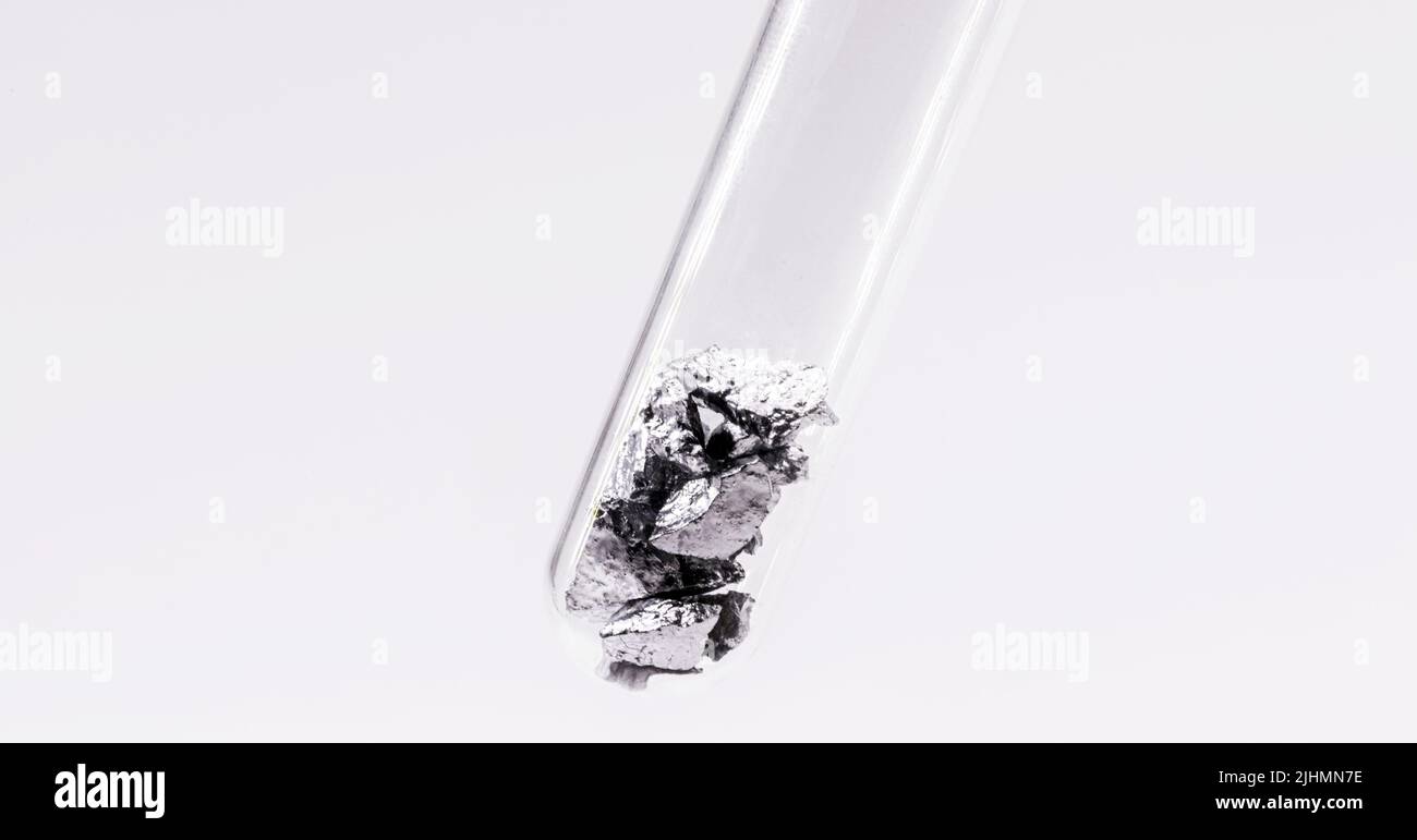 Chromium fragments inside test tube, industrial use ore, metallic chemical element, isolated on white background Stock Photo