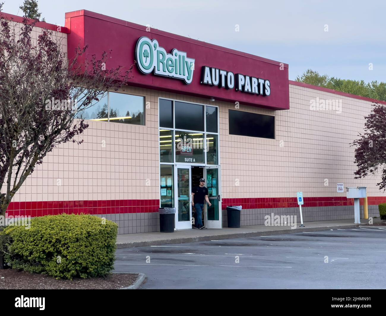 Lynnwood, WA USA - circa May 2022: Wide view of a man exiting an O'Reilly Auto Parts store. Stock Photo
