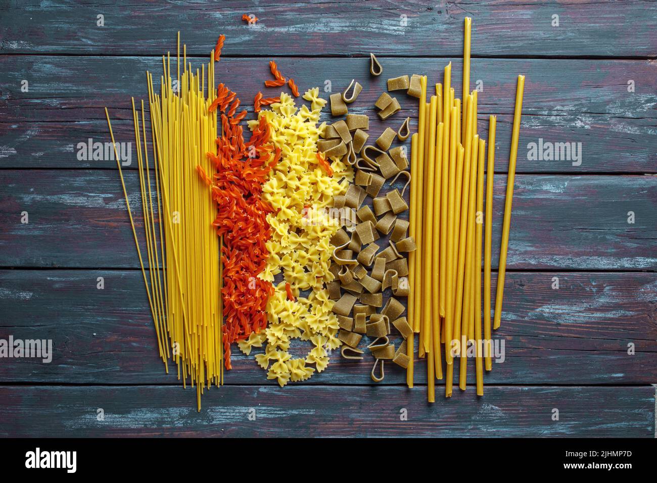 Multicolored italian pasta on old wooden table, flat lay Stock Photo