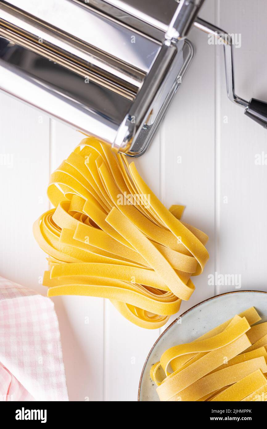 https://c8.alamy.com/comp/2JHMPPK/uncooked-pappardelle-pasta-on-a-white-table-top-view-2JHMPPK.jpg