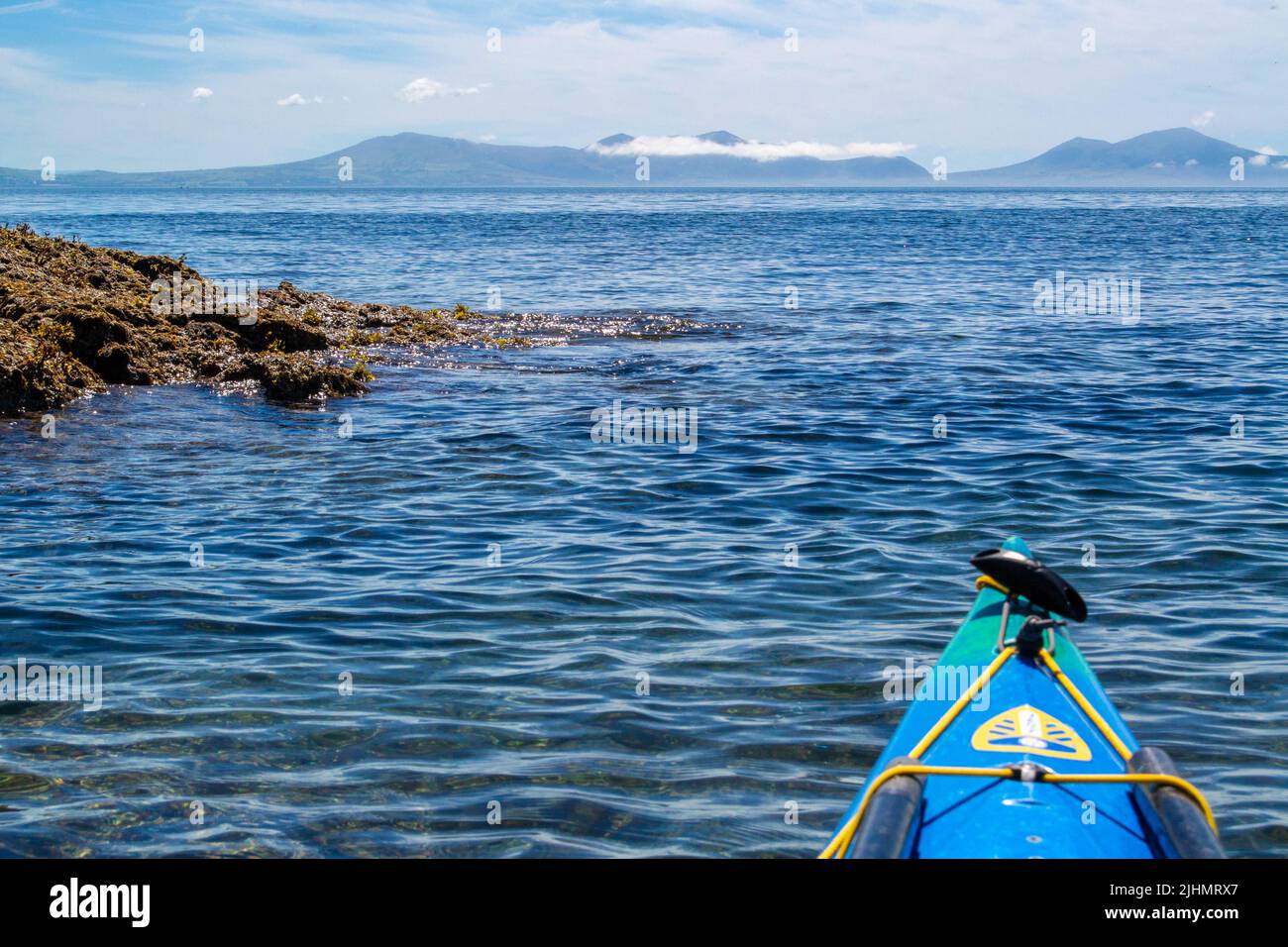Sea kayaking / canoeing on the coast of Anglesey, North Wales, UK Stock Photo