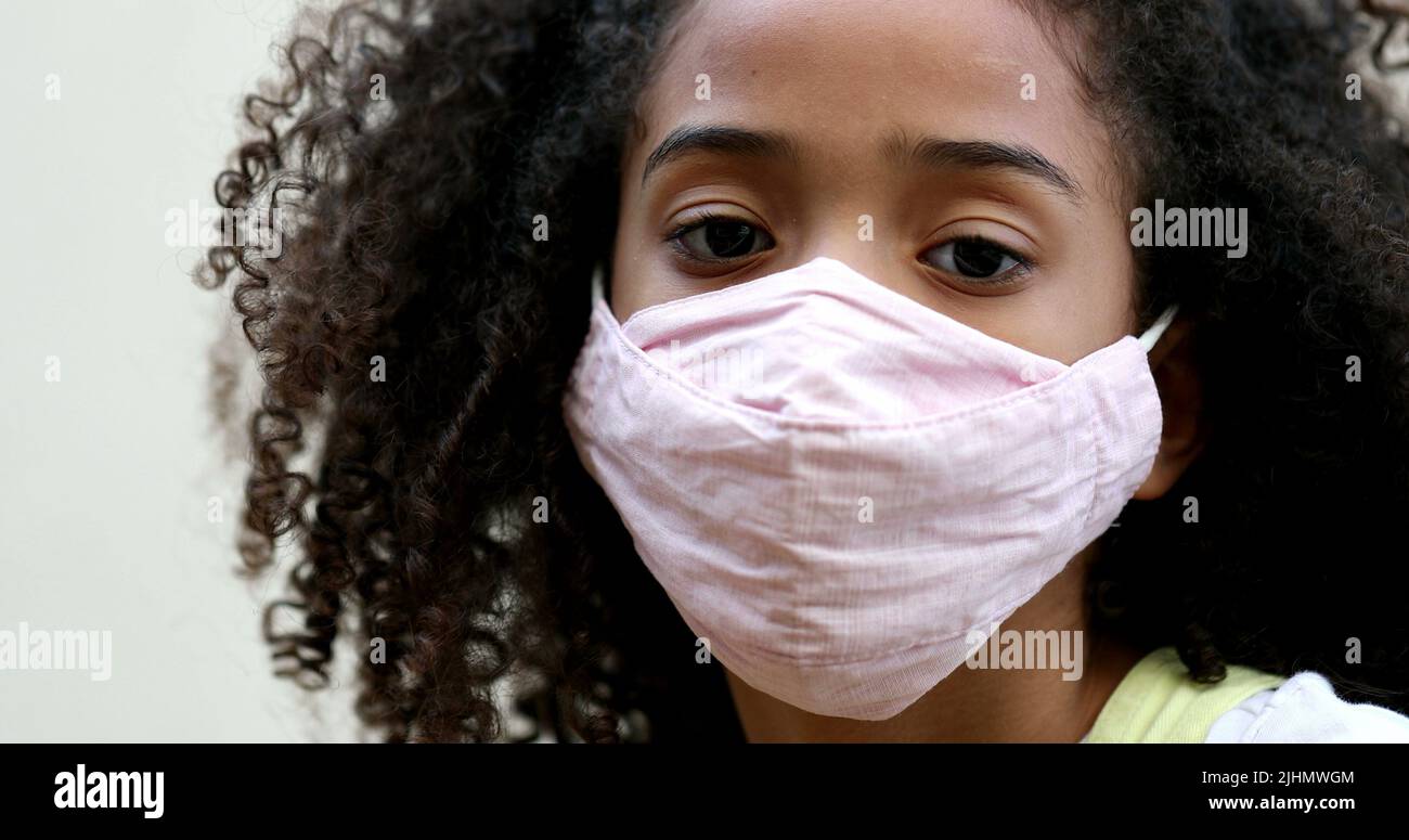 Little girl wearing covid face mask. Child wears preventive mask Stock