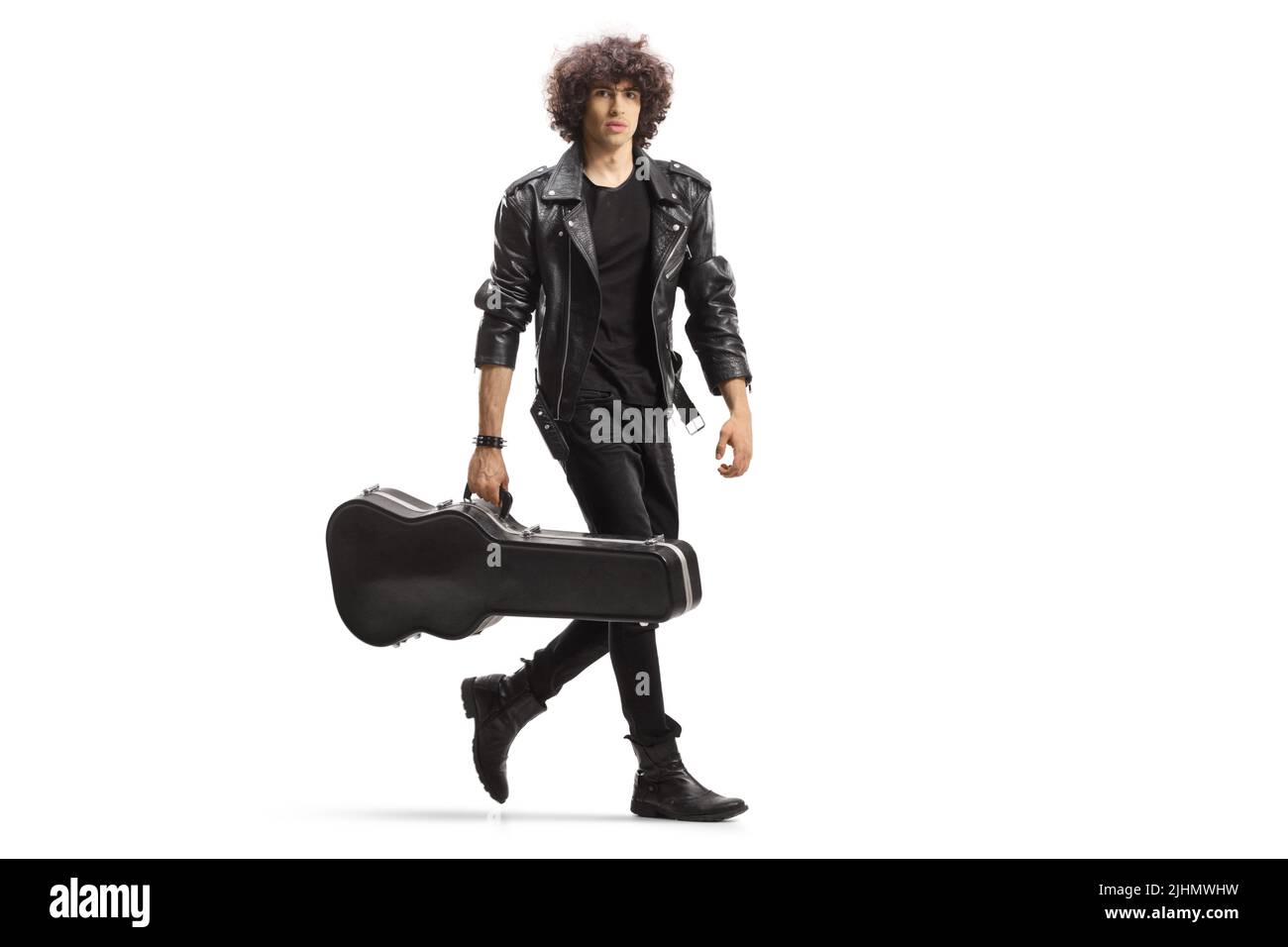 Full length portrait of a young rock musician carrying a guitar in a black case isolated on white background Stock Photo