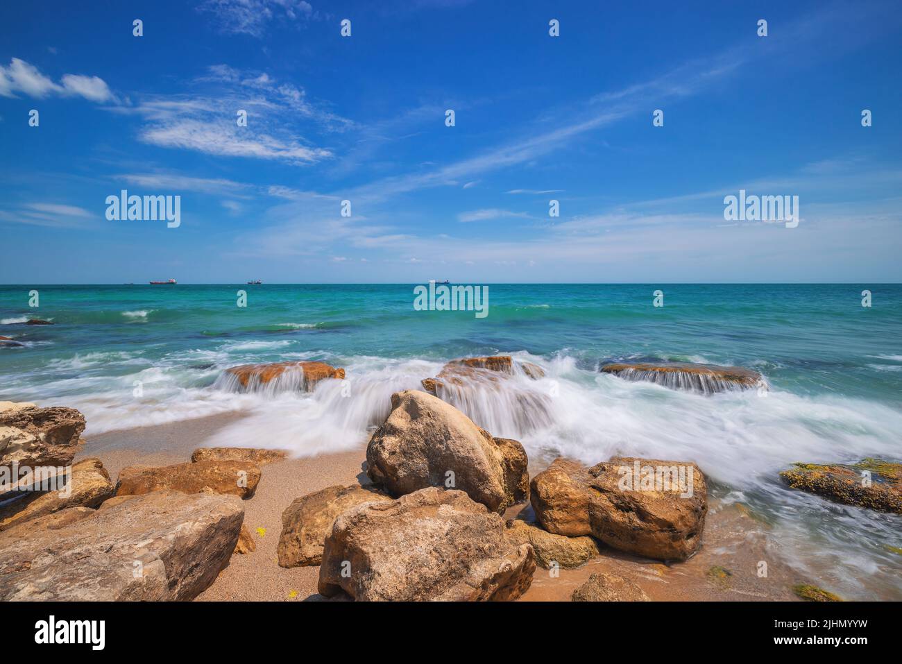 Wild exotic beach with rocks in sea water. Rocky island coastline Stock Photo