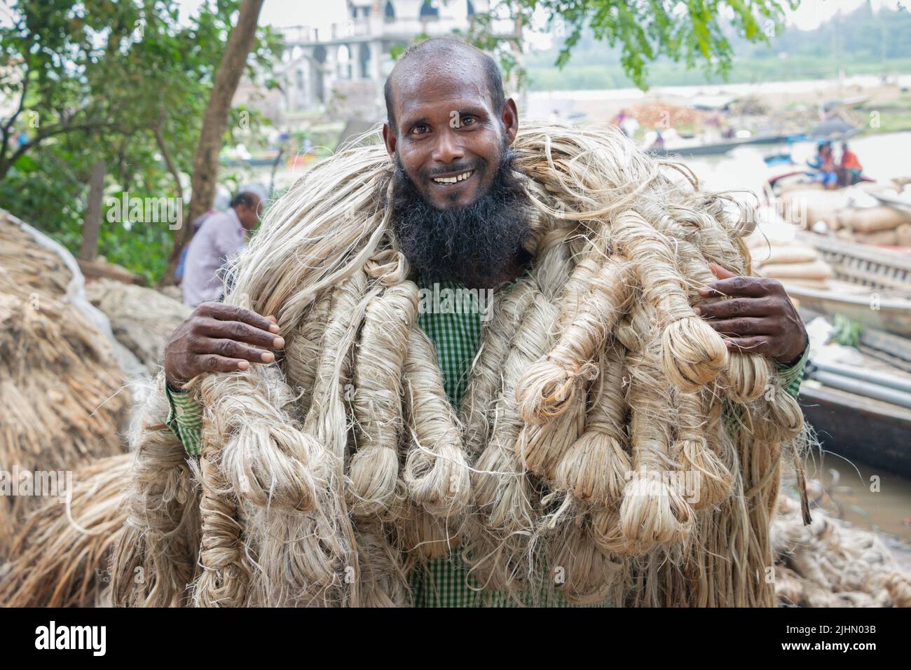July 20, 2022, Manikganj, Dhaka, Bangladesh Workers carry 50kg bundles