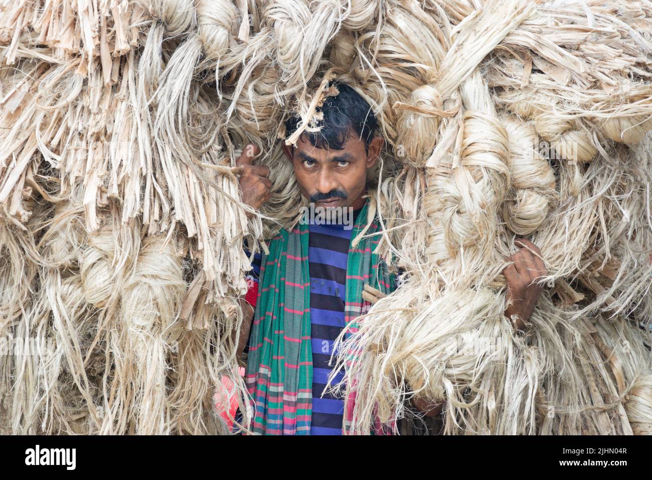 July 20, 2022, Manikganj, Dhaka, Bangladesh Workers carry 50kg bundles