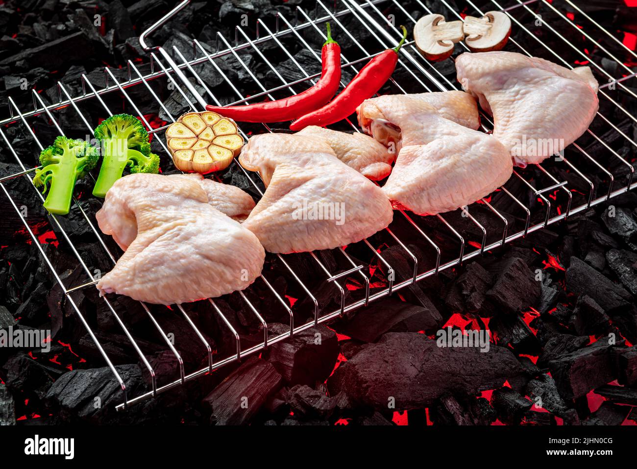 Raw chicken wings on the grill, hot coals of the grill. Barbecue and