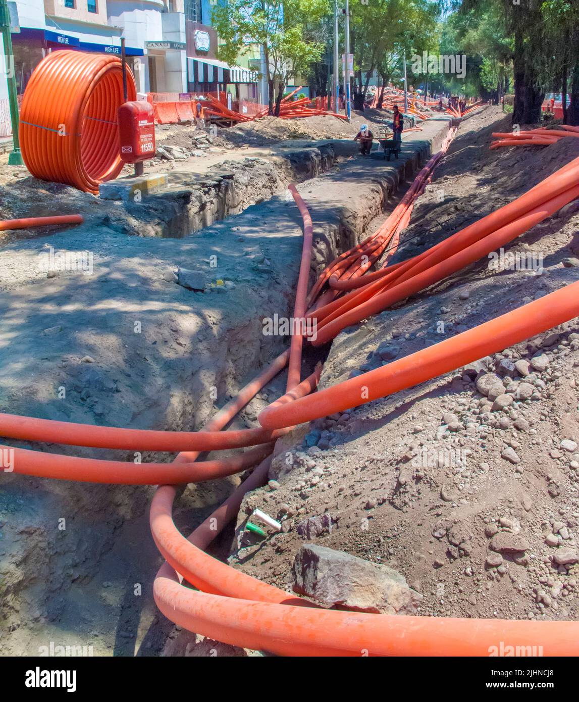 Workers laying pipes underground to carry telephone and internet lines Stock Photo