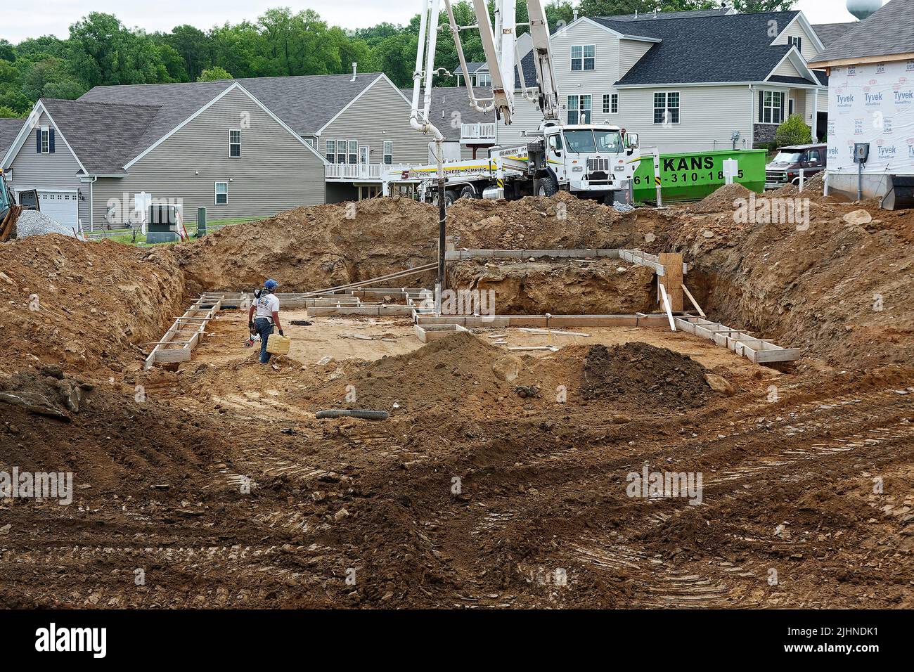 new house construction, foundation, dirt mounds;  completed homes, industry, equipment, man working, business, community,  Pennsylvania;  Chester Coun Stock Photo