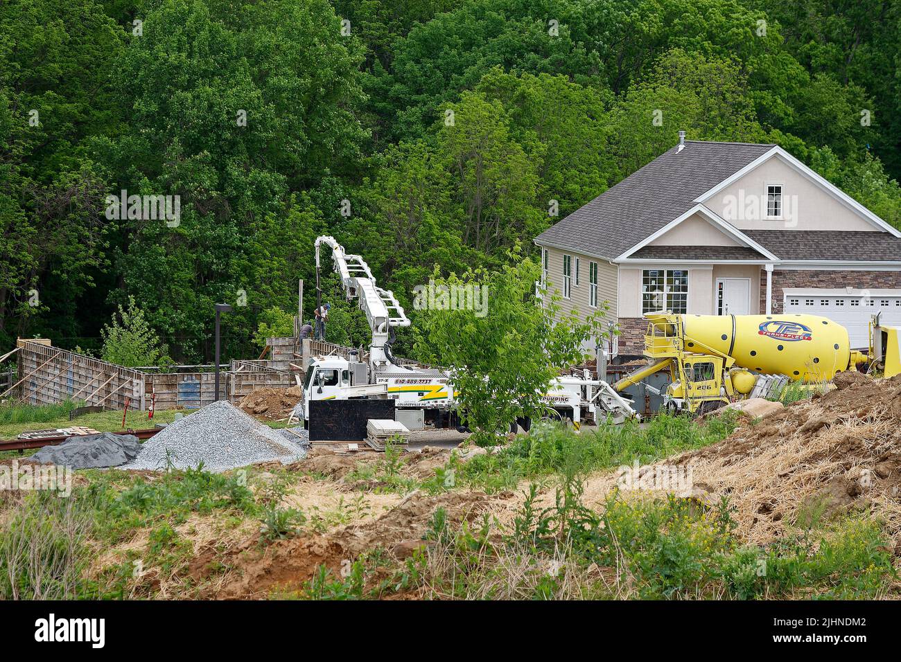new house construction, heavy  equipment, foundation, completed home, industry, men working, business, community, real estate,woods beyond, Pennsylvan Stock Photo