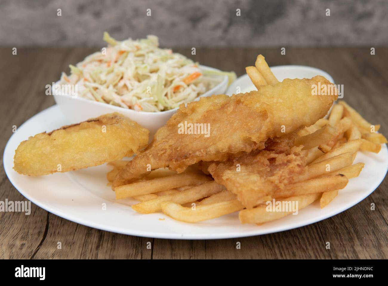 Tempting deep fried meal consisting of shrimp, fish, french fries, and cole slaw will ensure that the belly will be full. Stock Photo